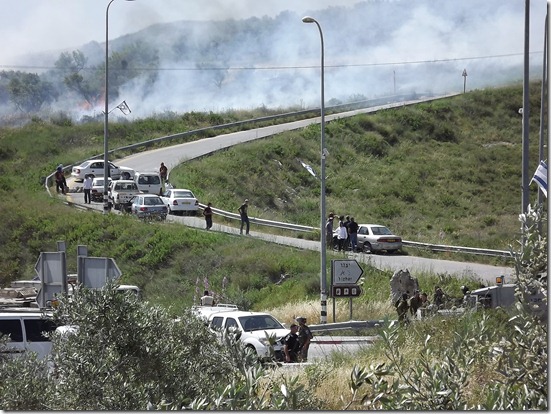 מתנחלים חוסמים כביש, שדות בוערים ברקע, חמושי מג"ב לא מתערבים (מוניר קאדוס, "יש דין")